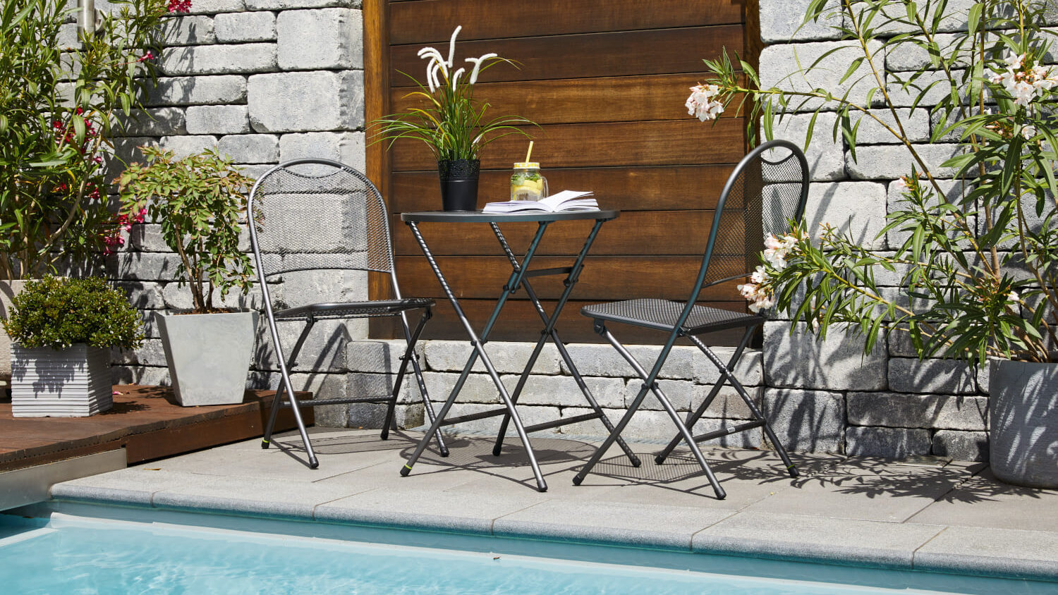 Blumen-Risse, Markenwelt, MWH, Header, Sitzgruppe, Balkonset, Klappstuehle, Klapptisch, Metall, Schwarz, Pool, Wasser, Hauswand, Ambiente