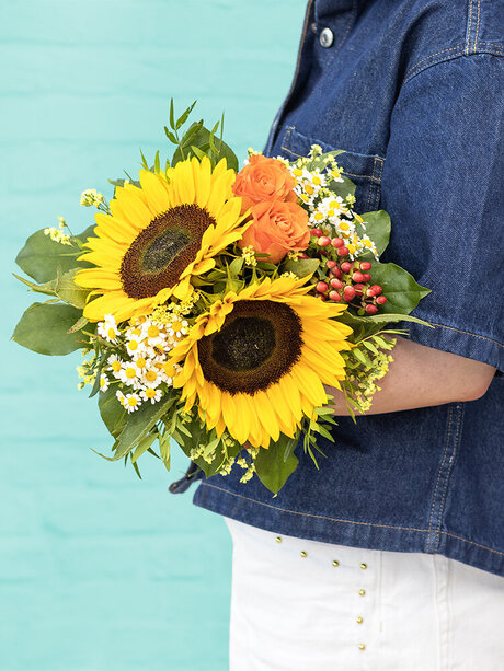 Blumen-Risse, Strauss-der-Woche-KW29, Gelb, Orange, Gruen, Blau, junge-Frau-haelt-Sonnenblumenstrauss