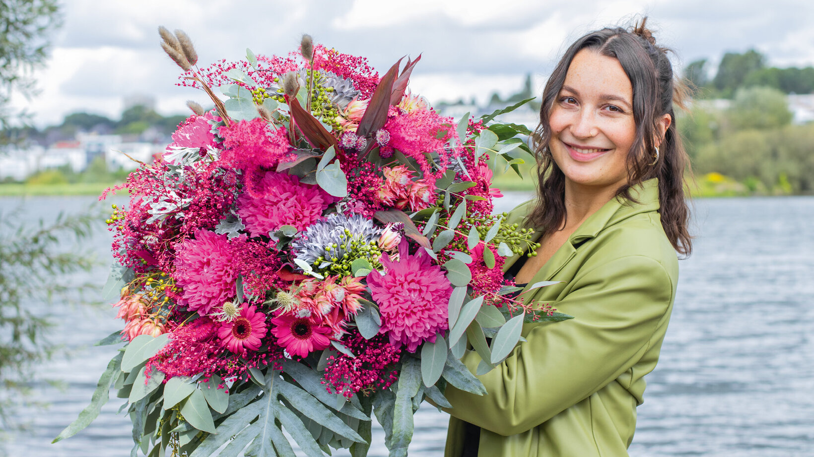 Blumen-Risse, Aktuelles, Herbstfloristik, Pink, Grey, Der-Herbst-im-Farbenrausch, Frau-healt-grossen-Herbststrauss-vor-Phonixsee