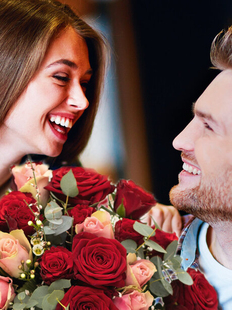 Blumen-Risse, Valentin, Valentinstag-am-14.-Februar, glueckliches-verliebtes-Paerchen-mit-Rosenstrauss