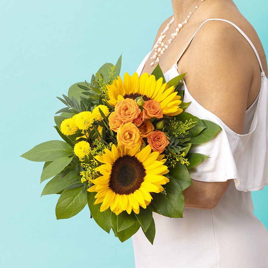 Frau hält Sonnenblumenstrauß