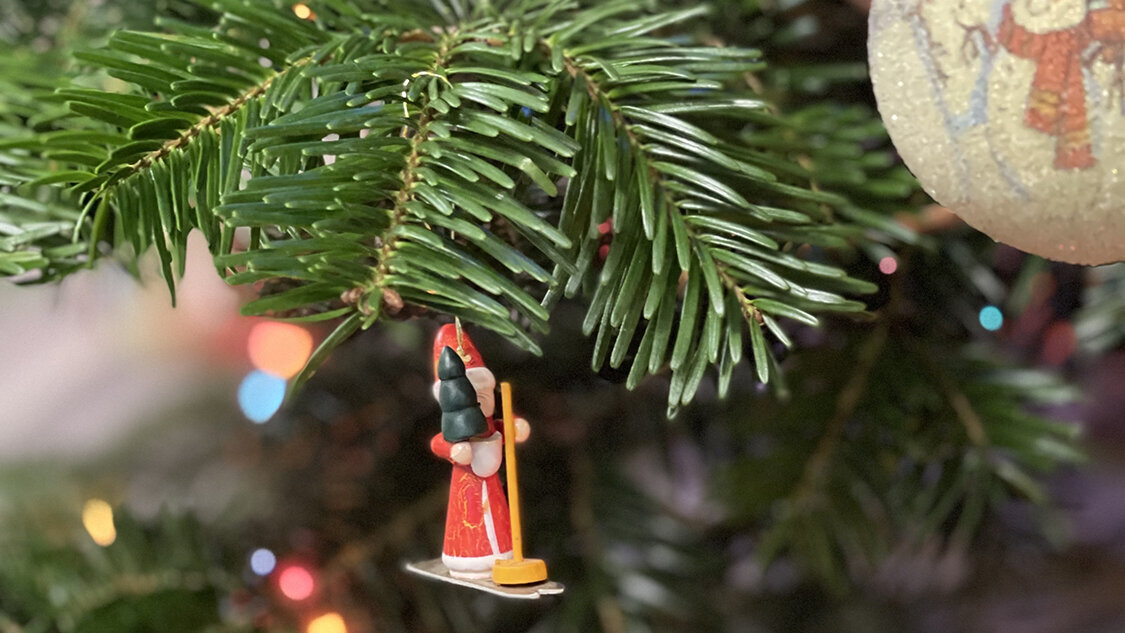 geschmeuckter-Weihnachtsbaum-mit-bunten-lichtern-und-Holzfigur