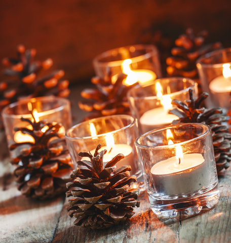 Blumen-Risse-Tannenzapfen-Teelichter-Kerzenschein-Holztisch-Weihnachtsgefühl-Stimmungsvoll