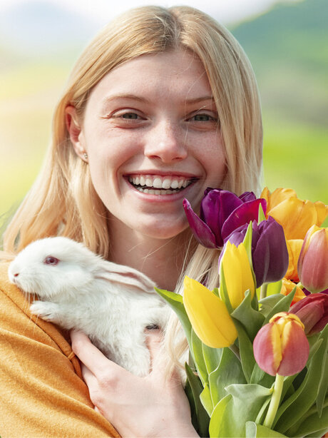 Blumen-Risse, Aktuelles, Ostern, Frau-mit-Tulpen-hat-weissem-Hasen-auf-dem-Arm