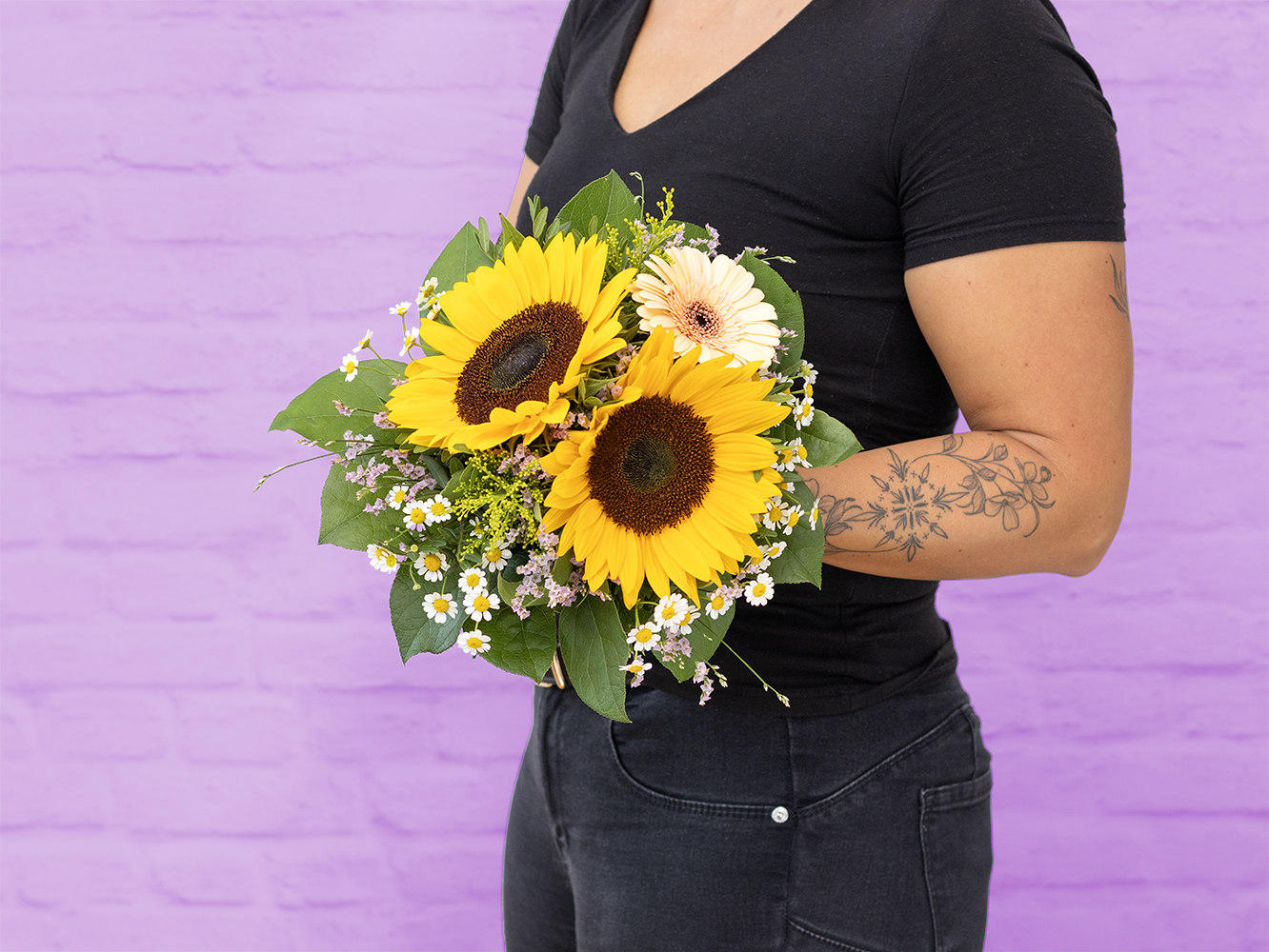Blumen-Risse, Strauss-der-Woche-KW27, Gelb, Gruen, Frau-haelt-Sonnenblumenstrauss-vor-Oberkoerper